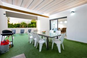 une salle à manger avec une table et des chaises blanches dans l'établissement Luxury Apartment, à Adeje