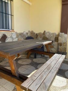 un tavolo da picnic in legno di fronte a un divano in pietra di Apartamentos Turísticos Carmencita a Bolonia