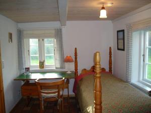 1 dormitorio con 1 cama, escritorio y 2 ventanas en Fischerkate-mit-schoenem-Garten, en Sankt Peter-Ording
