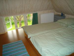 Un dormitorio con una cama grande y una ventana en Fischerkate-mit-schoenem-Garten, en Sankt Peter-Ording