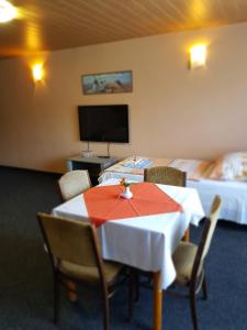 a room with a table and chairs with two beds at Guest House Pod Lesem Merklín in Merklín