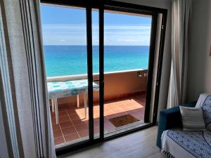a view of the ocean from a room with a sliding glass door at Pinus Village Apartments 4 vista mare in Fort Village