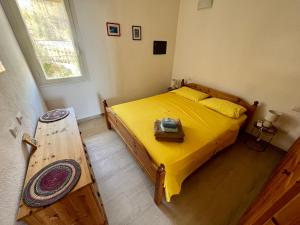 Un dormitorio con una cama amarilla y una mesa en Pinus Village Apartments 4 vista mare en Fort Village