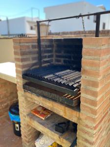 a brick fireplace with a grill on top of it at Apartamentos Turísticos Carmencita in Bolonia