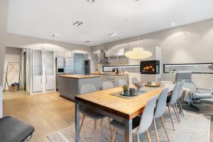 een keuken en eetkamer met een houten tafel en stoelen bij Oceanfront penthouse duplex wamazing view! in Tromsø +33 foto's