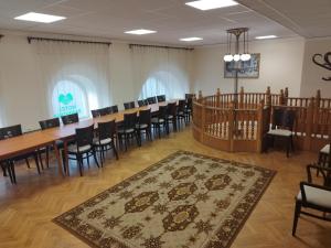 a room with a long table and chairs and a rug at Hotel Pannonia in Miskolc