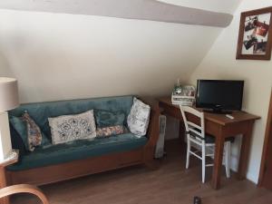 - un salon avec un canapé et un bureau avec un ordinateur dans l'établissement Le Clos du Buisson, à Saint-Julien-de-la-Liègue