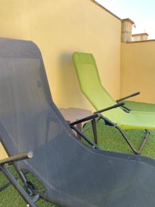 two green chairs sitting next to each other at Apartamentos Turísticos Carmencita in Bolonia
