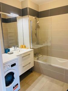 La salle de bains est pourvue d'un lave-linge et d'une douche. dans l'établissement Appartement T3 Confluence, à Lyon