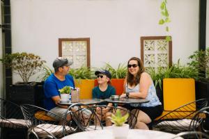 una famiglia seduta a un tavolo in un ristorante di Haemer Villa Hoi An a Hoi An