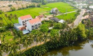會安的住宿－Haemer Villa Hoi An，享有棕榈树和河流的度假胜地的空中景致