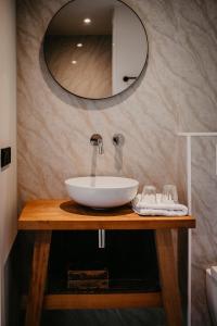 een badkamer met een witte wastafel en een spiegel bij Motel-Restaurant-Grand Cafe de Caisson in Kapelle