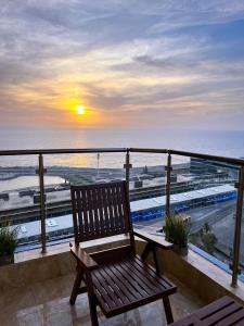 a wooden bench sitting on a balcony overlooking the ocean at شقة ملكيه فاخرة مطله على البحر in Jeddah