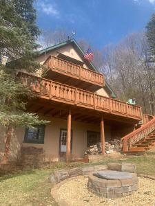 a large house with a deck on top of it at 3 Bedroom Cabin at Alpine Lake, near Deep Creek-WISP Resort in Terra Alta