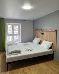 a bed in a room with a green window at FOKA Hostel in Wrocław