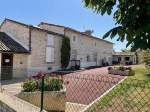 een huis met een hek ervoor bij Chambres d'hôtes du puy d'anché in Sauzé-Vaussais