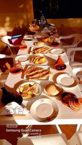 una mesa larga con platos de comida. en دوار ابغاوة ازغيرة تروال سد الوحدة وزان en Srija