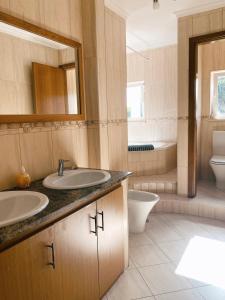 un bagno con due lavandini e un WC di Good Vibes Villa ad Aljezur