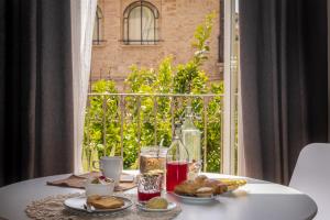 une table avec une assiette de nourriture et une fenêtre dans l'établissement B&B La Finestra Sui Tetti, à Lanciano