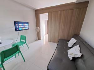 a living room with a couch and a table and a tv at Elresa Elegant at Field Residences Condominium Hotel in Manila