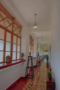 a hallway with windows and a row of stools at Marari Beach Bungalow Resort Alleppey in Mararikulam