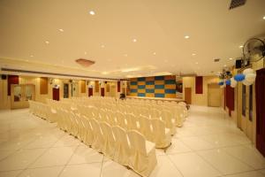 a banquet hall with white chairs and white tables at Chandra Residency in Dharmapuri