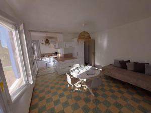 uma sala de estar com uma mesa e um sofá em Maison Marseillan-Plage, 3 pièces, 6 personnes - FR-1-326-772 em Marseillan