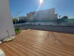 um deque de madeira em frente a um edifício em Maison Marseillan-Plage, 3 pièces, 6 personnes - FR-1-326-772 em Marseillan