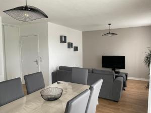 een woonkamer met een bank en een tafel bij appartement vacances en copropriété avec parking in Saint-Malo