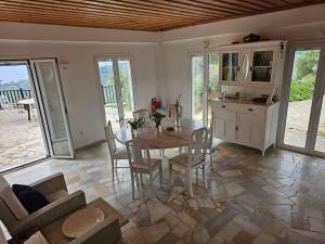 - une cuisine et une salle à manger avec une table et des chaises dans l'établissement Peloponnese Hideout - White house with the sea view, à Akrata