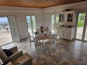 cocina y comedor con mesa y sillas en Peloponnese Hideout - White house with the sea view en Akrata