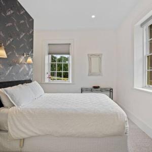 a white bedroom with a large bed and a window at LUCAS Street in Kingston