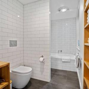 een witte badkamer met een toilet en een bad bij LUCAS Street in Kingston