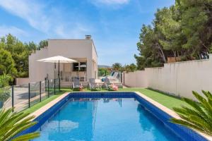a swimming pool in the backyard of a house at Villa Kobe - Plusholidays in Teulada