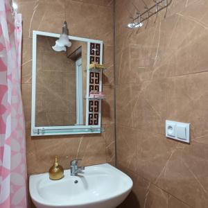 W łazience znajduje się umywalka i lustro. w obiekcie Magdan house w mieście Ckaltubo