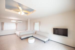 a living room with a couch and a flat screen tv at BLUE MOON in Kawazu +10 photos