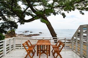 a table and chairs on a deck with a view of the ocean at BLUE MOON in Kawazu