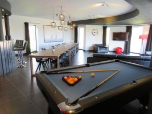 a pool table in a living room with a bill at Oxygen House, Holiday and Team building in Ovifat