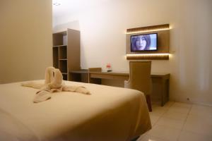 a hotel room with a bed and a television at Front One Resort Indraloka Temanggung in Temanggung