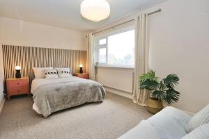 xxBrand Newxx sleeps 8, stylish japandi house في بلاكبول: غرفة نوم بسرير ونافذة كبيرة