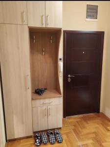 Zimmer mit Tür und Schuhreihe in der Unterkunft Apartment Spens in Novi Sad