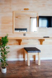 um quarto de madeira com um banco e uma mesa em Serenity Bungalows em Cıralı