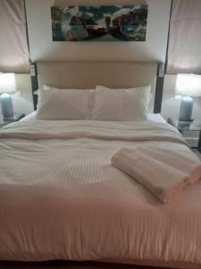 uma cama branca com 2 candeeiros e 2 almofadas em Peaceful Private Villa at Five Star Beach Resort em Ras al-Khaimah