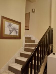 Peaceful Private Villa at Five Star Beach Resort في رأس الخيمة: درج في منزل عليه لوحة على الحائط