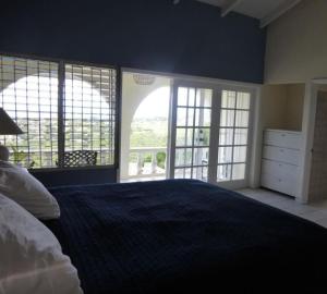 um quarto com uma cama grande e janelas grandes em Famili Villa em Old Towne