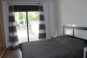sypialnia z łóżkiem i przesuwanymi szklanymi drzwiami w obiekcie Appartement tout confort, Rez-de chaussée,3 chambres, 2 salles de bain w mieście Sant Jordi +35 zdjęć