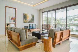 uma sala de estar com duas cadeiras e uma mesa em Cempaka 5 Villa 7 bedroom with a private pool em Bandung