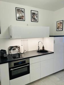 een witte keuken met een wastafel en een fornuis bij Zollernalbdomizil FeWo2 in Balingen