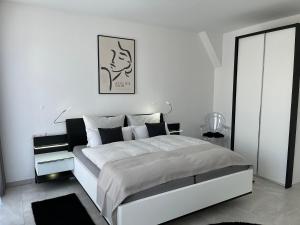 een witte slaapkamer met een groot wit bed. bij Zollernalbdomizil FeWo2 in Balingen