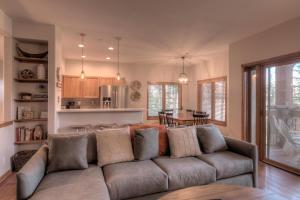 a living room with a couch and a kitchen at Los Pinos Columbine Condo Nice Updates Stroll to Lift in Breckenridge